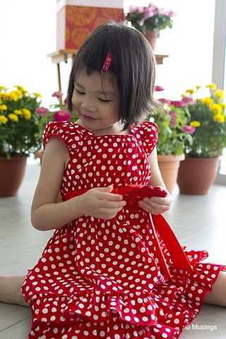 In a red polka dot dress, and visiting a Minton neighbor's home.