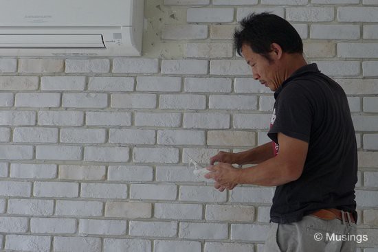 The worker showing how it's done. Laying each brick with compound first... 