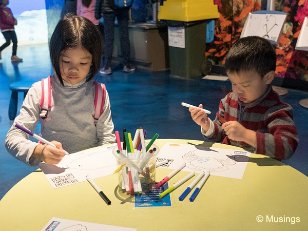 Kids coloring their fishes for scanning into the computer. 