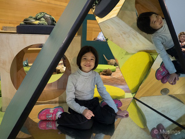 A glass mirror pyramid for kids to crawl into.